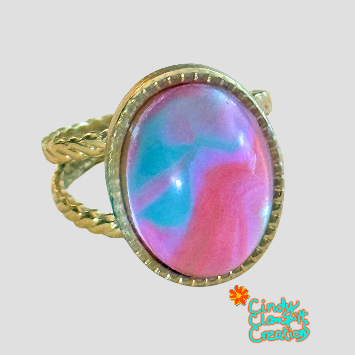 Hand-painted pink and teal swirl oval glass cabochon ring on an 18K gold plated twisted rope open cuff band by Cindy Clampitt Creations