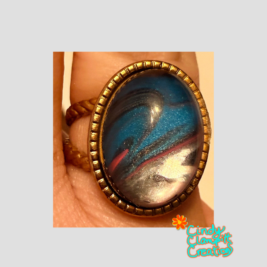 Hand-painted deep cobalt blue and navy swirl with magenta and silver oval glass cabochon ring on an 18K gold plated twisted rope open cuff band by Cindy Clampitt Creations