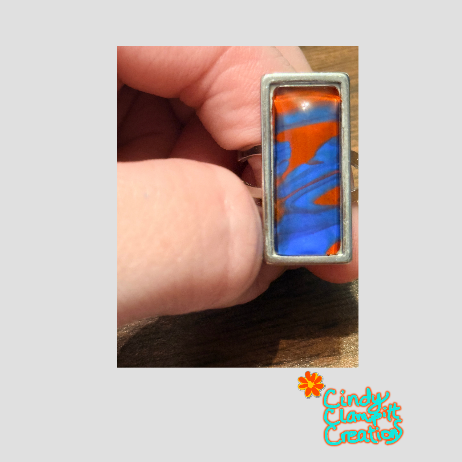 Hand-painted cranberry red and cobalt blue swirl glass cabochon ring on a stainless steel open-back band by Cindy Clampitt Creations
